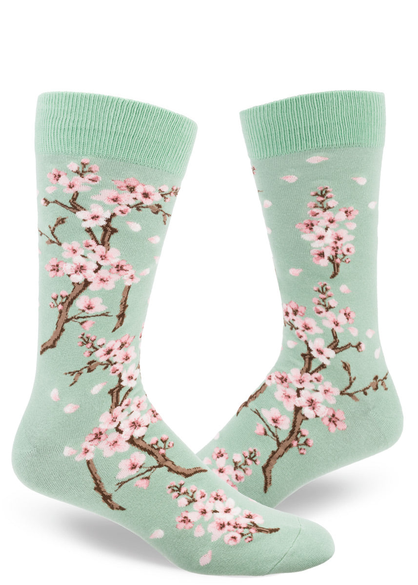 Spring crew socks for men feature pale pink cherry blossoms on a mint green background.