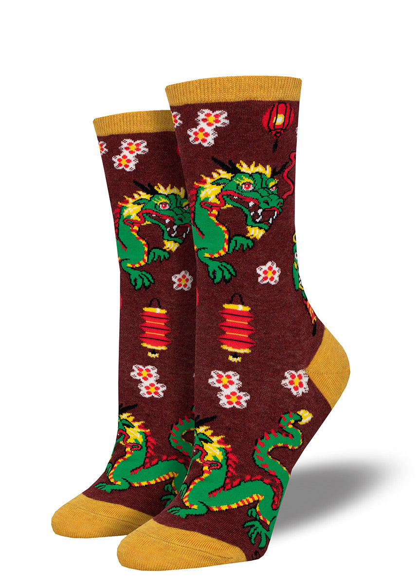 Chinese New Year socks with a pattern of green dragons, red paper lanterns and peach blossoms over a burgundy background, accented with a gold heel, toe and cuff.