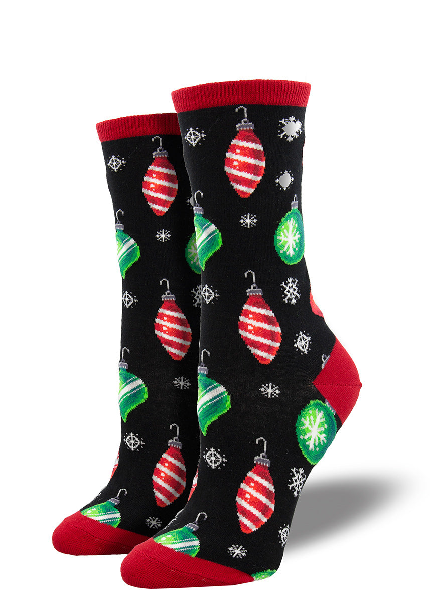 Christmas socks for women feature glass blown ornaments and snowflakes on a black background.