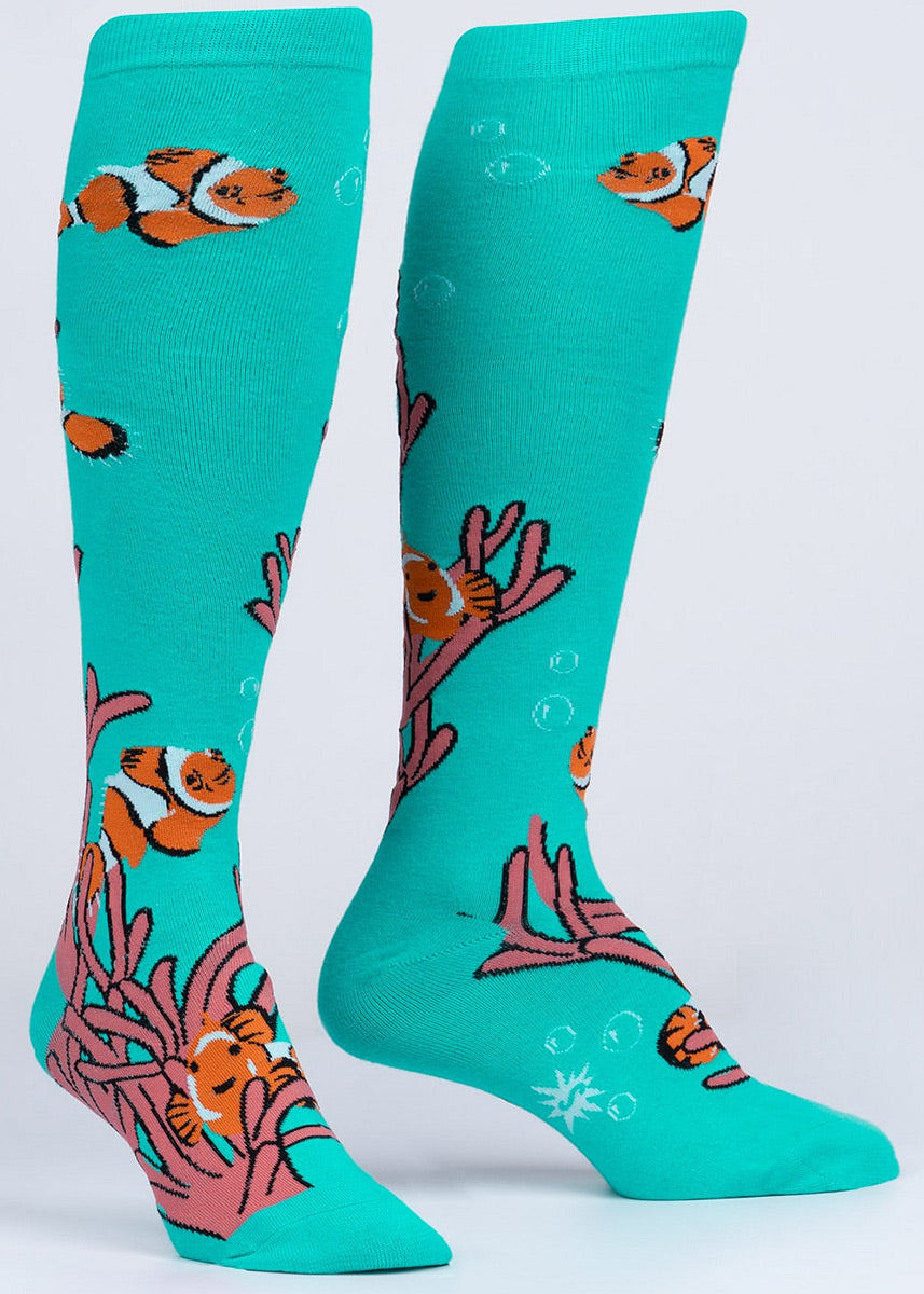 Fish knee socks feature orange and white clownfish and pink anemones on an aqua background.