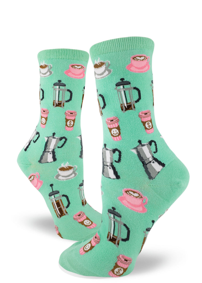Coffee socks for women with French press coffee pots, cups of coffee and to-go cups of coffee on a seafoam green background.