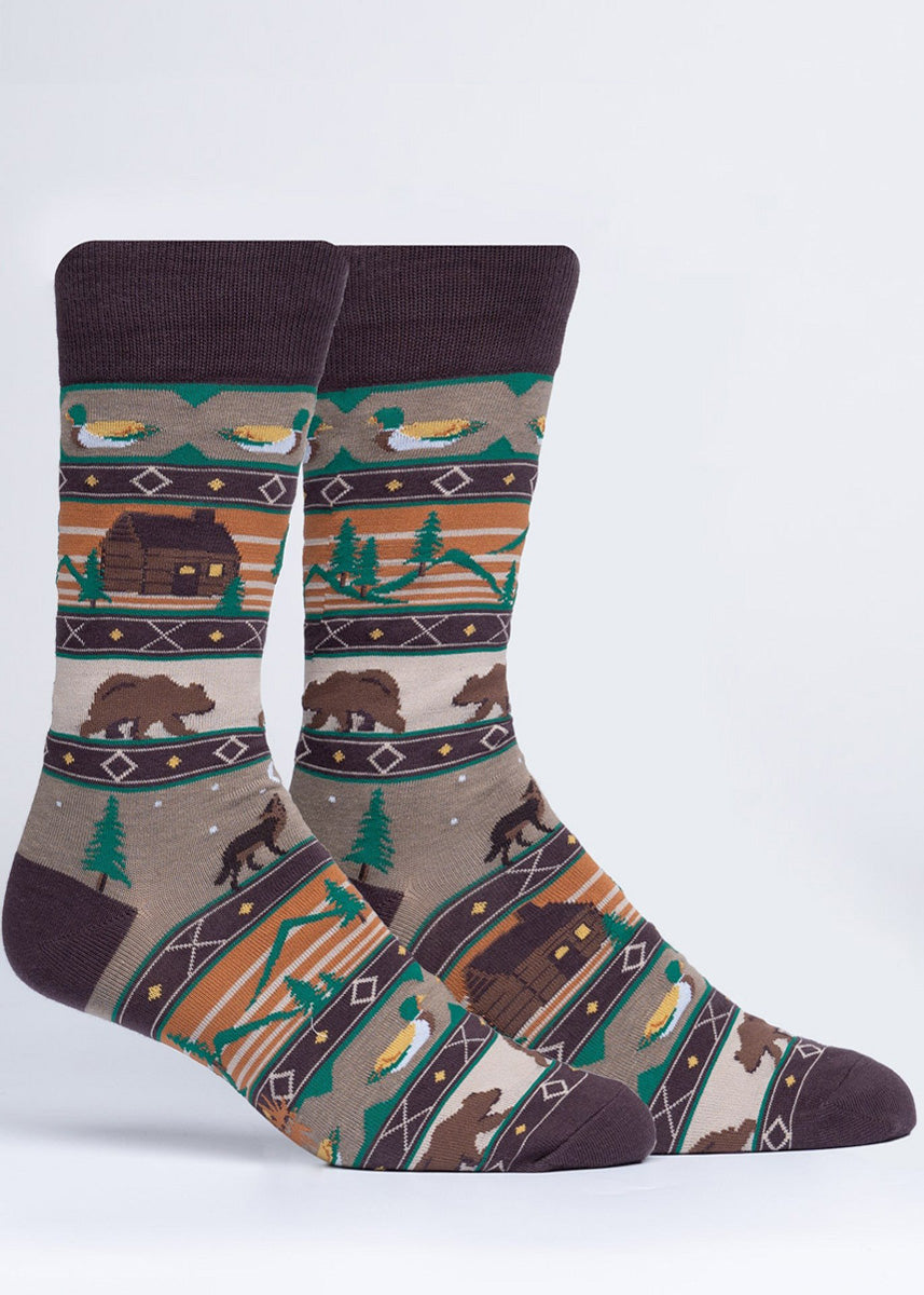 Camping socks for men feature a sweater print that includes a cozy log cabin, brown bears, mallard ducks, wolves howling, and a mountain landscape!