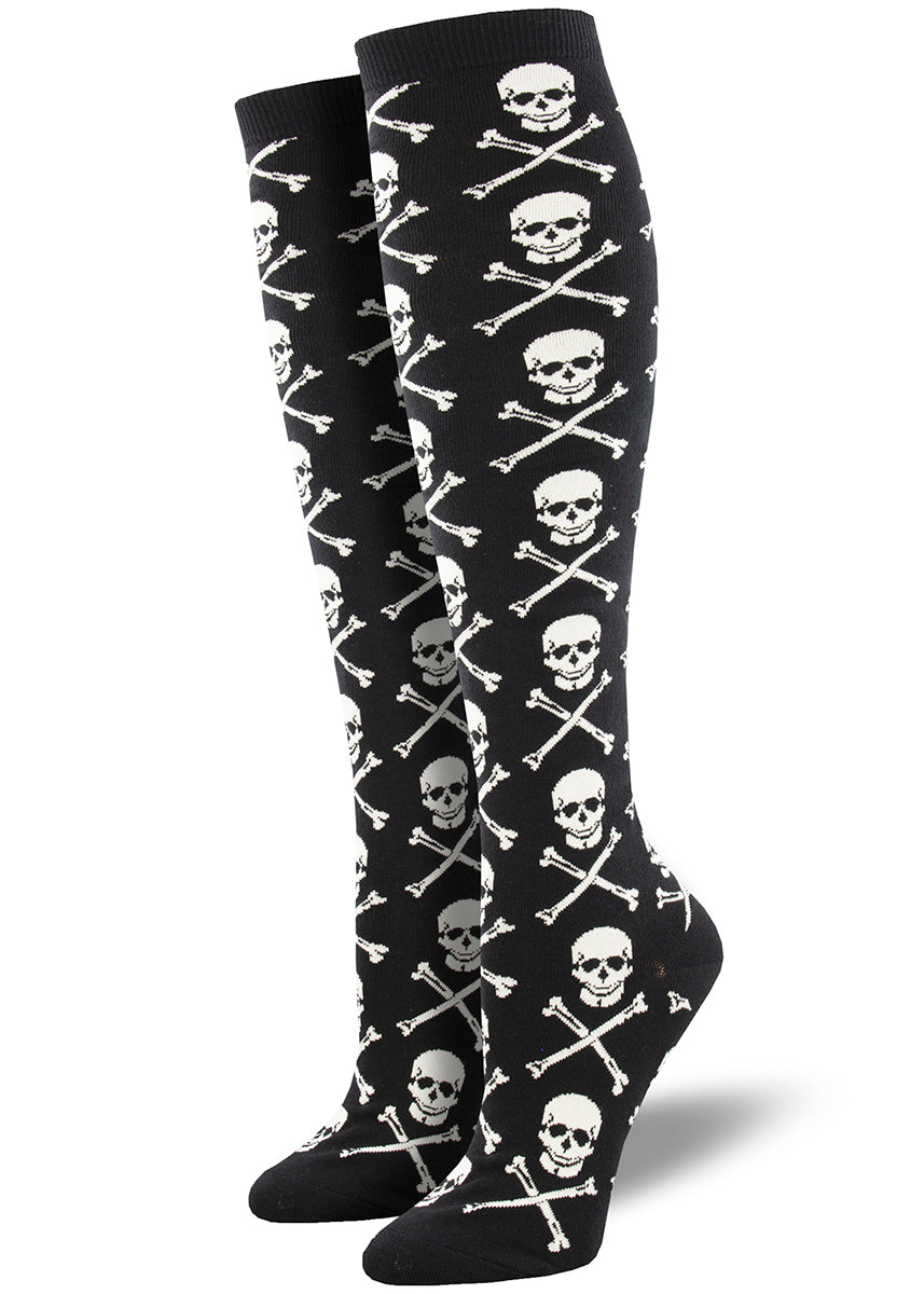Knee-high socks for women feature a repeating pattern of a skull and crossbones on a black background.