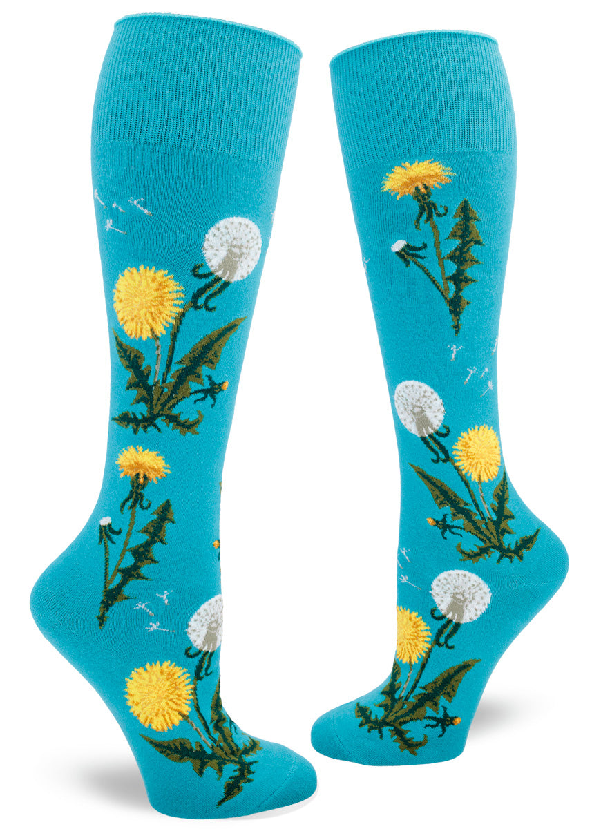 Blue knee socks with a roll-top cuff feature a pattern of yellow dandelion flowers, some with their seeds scattering in the wind.