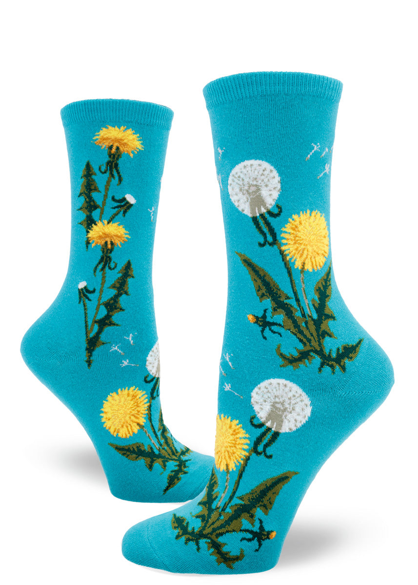 Blue women&#39;s crew socks feature a pattern of yellow dandelion flowers, some with their seeds scattering in the wind.