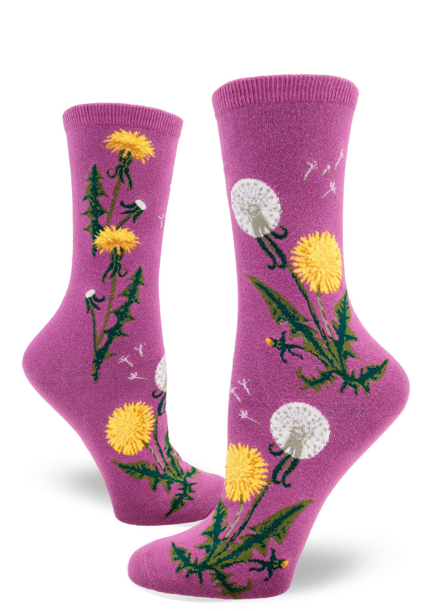 Magenta women&#39;s crew socks feature a pattern of yellow dandelion flowers, some with their seeds scattering in the wind.