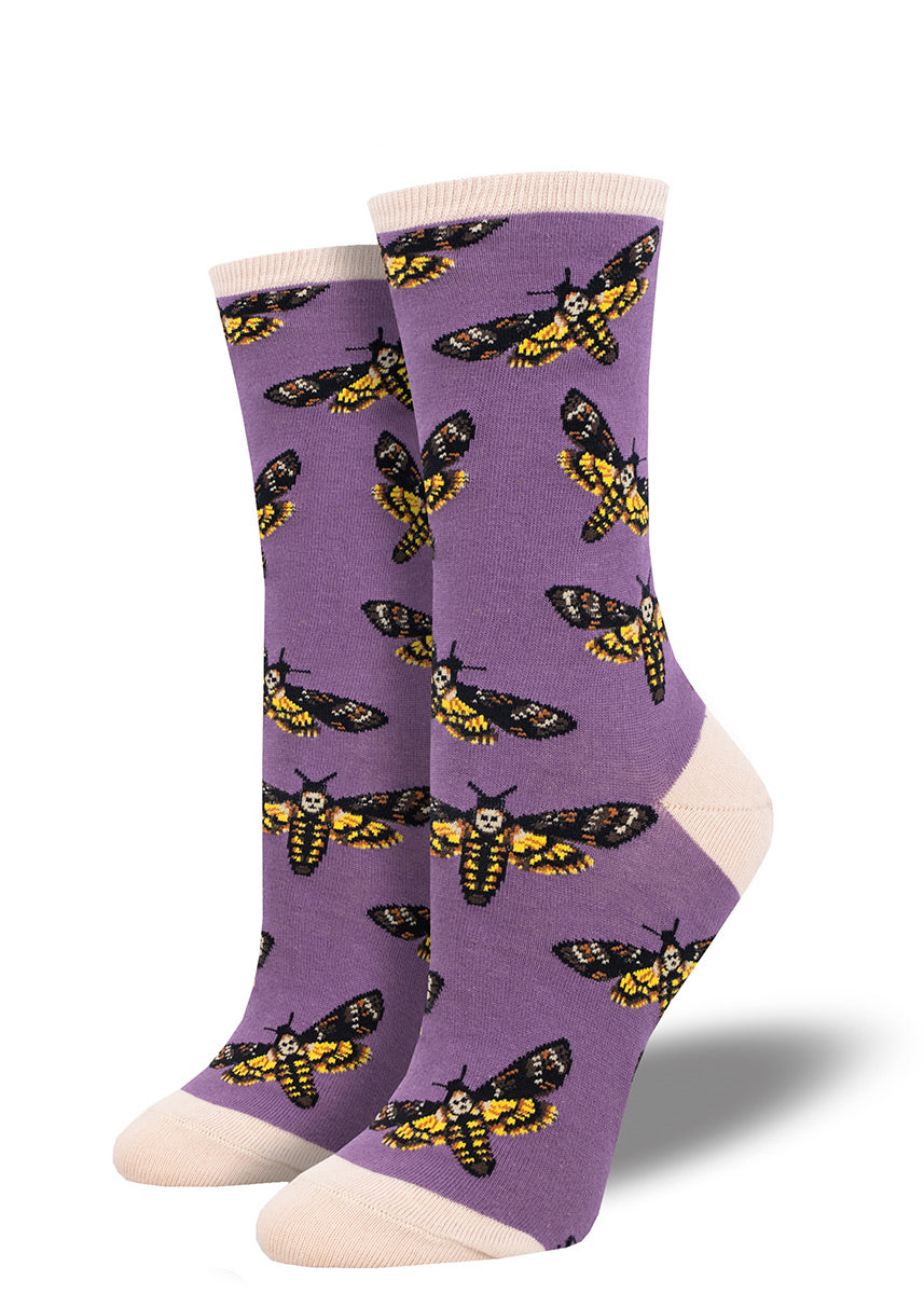 Novelty socks with a repeating pattern of death&#39;s head hawkmoths on a purple background with contrasting ivory heel, toe and cuff.