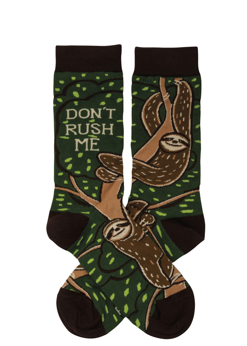 Funny animal socks show brown sloths hanging from trees with the words, "Don't rush me."