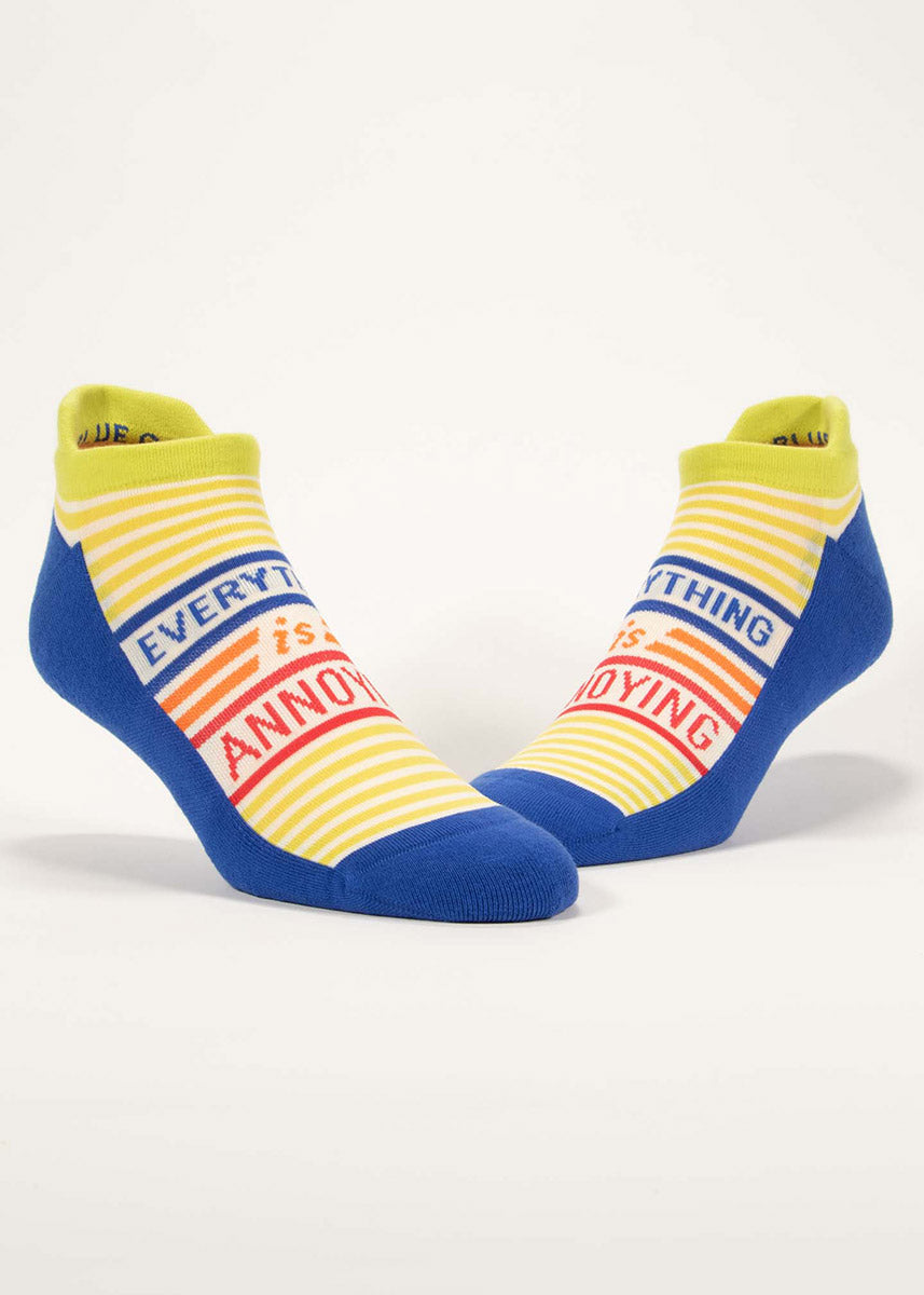 Athletic ankle socks with a lime green and white striped foot that says “Everything is Annoying” on top, accented with a blue cushioned footbed.