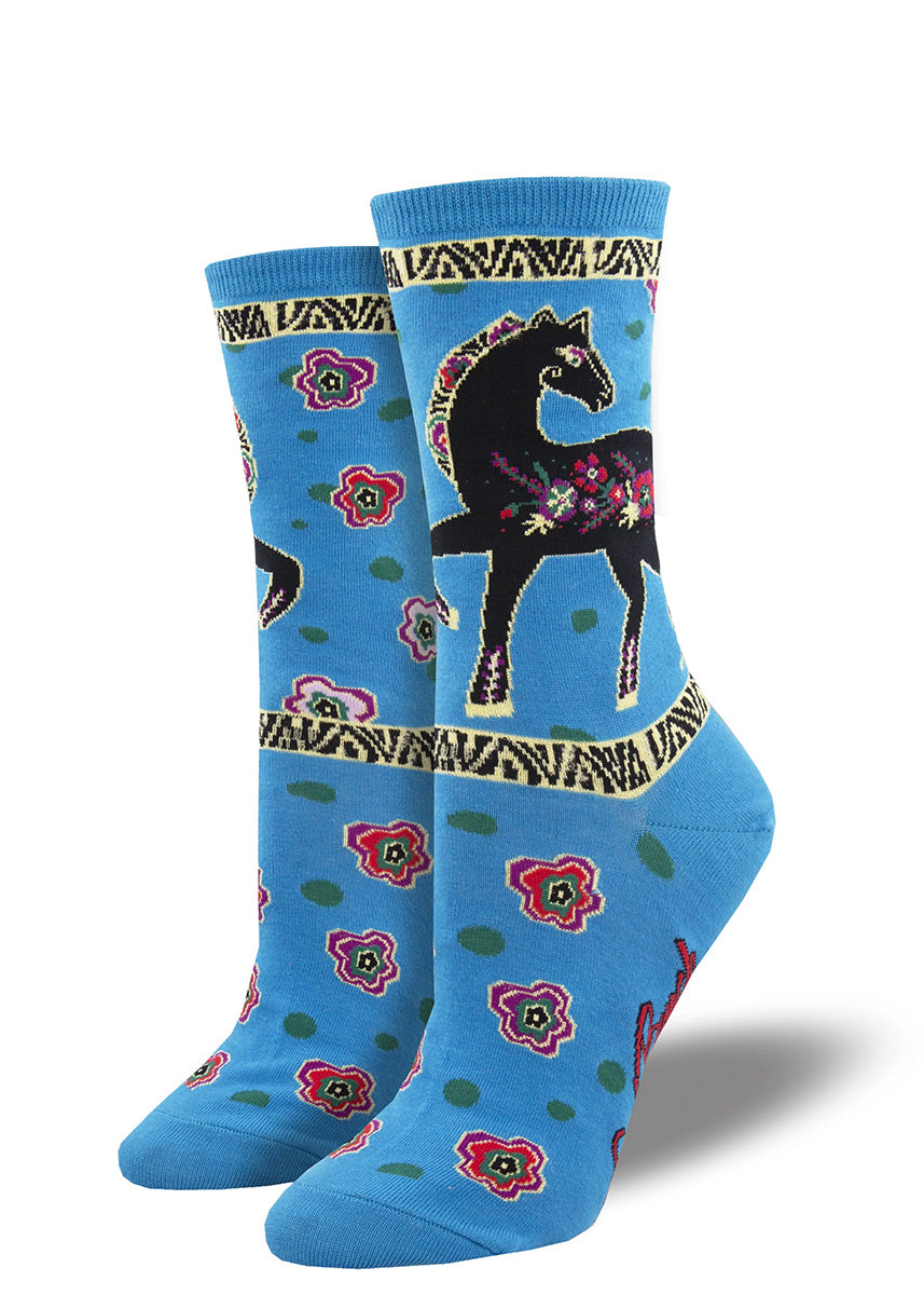 Blue crew socks featuring Laurel Burch horse art depicting a black stallion adorned with colorful flowers.