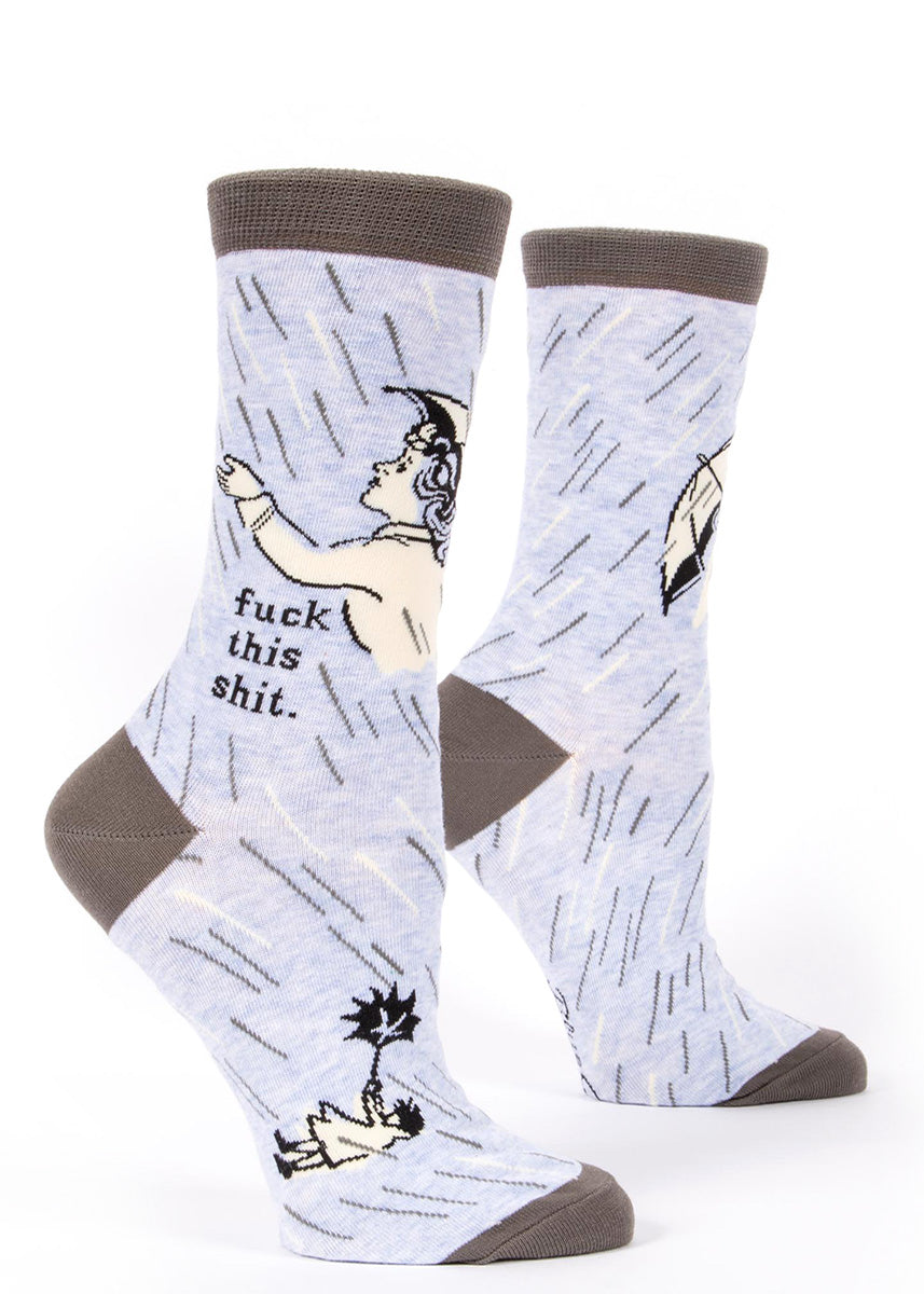 "Fuck This Shit" socks by Blue Q are blue and gray with a lady caught in a rainstorm with her umbrella.