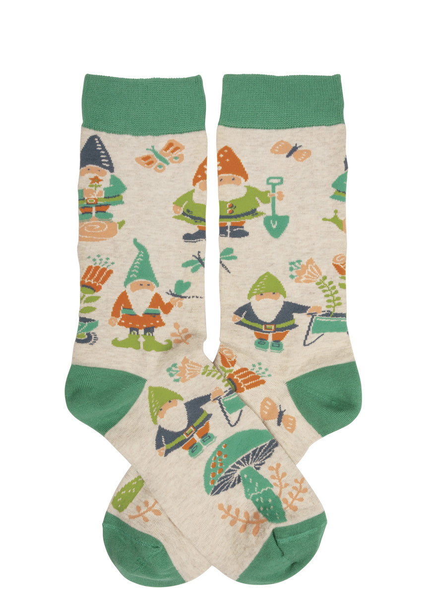 Garden socks for women feature adorable garden gnomes planting flowers and playing with butterflies on a taupe background with green accents.