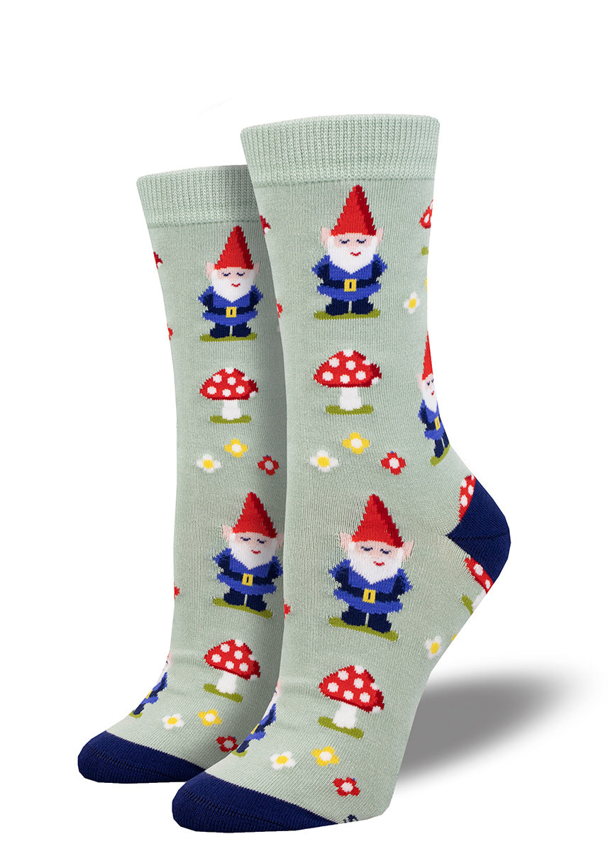 Pale green crew socks for women with a repeating pattern of garden gnomes, flowers and red toadstools.