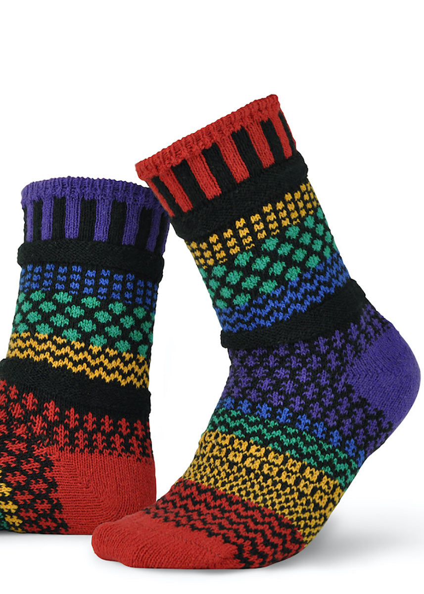 Mismatched socks feature funky patterns in bands of red, yellow, green, indigo, and purple.