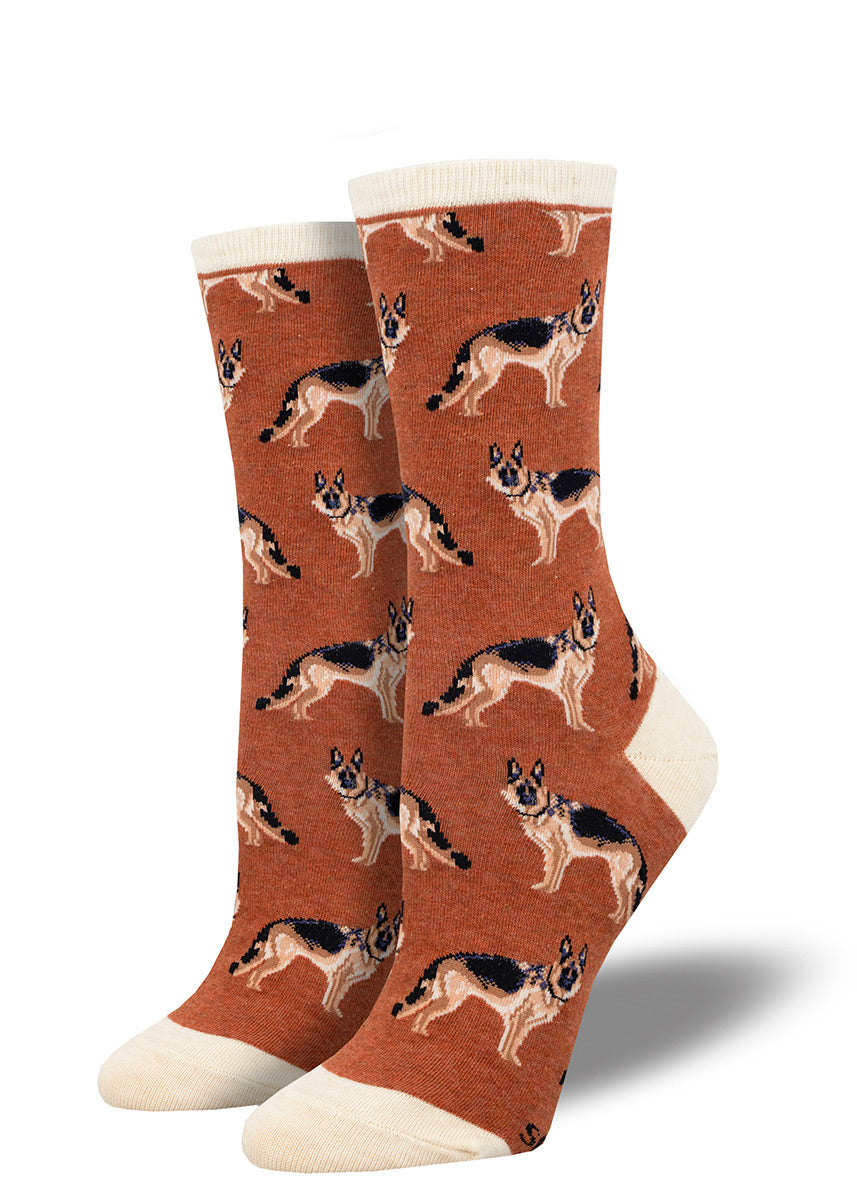 Rust-toned women&#39;s crew socks feature a repeating pattern of German Shepherd dogs and are accented with cream at the heel, toe and cuff.