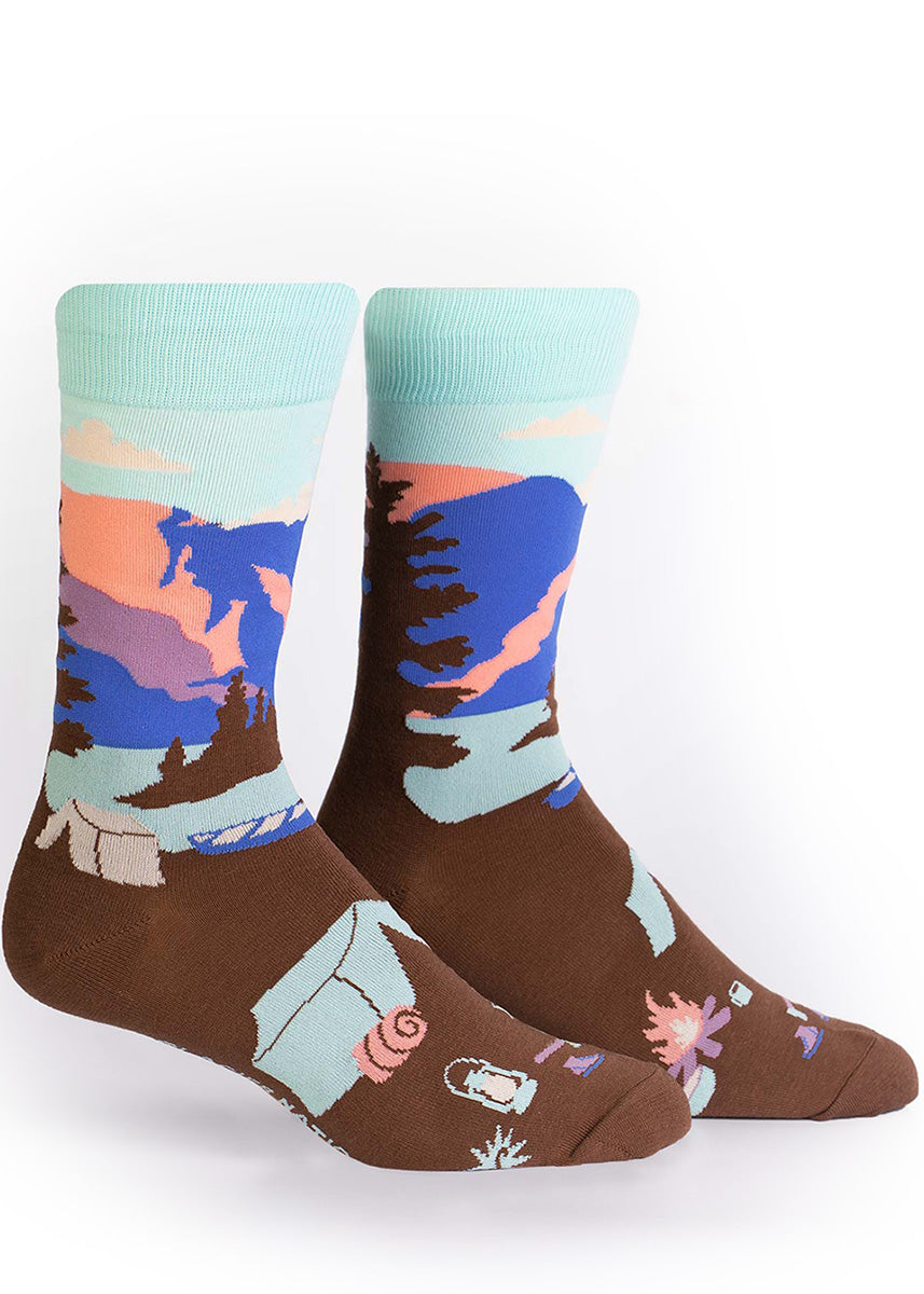 Glacier National Park socks for men show a tent and camping gear next to a lake with beautiful mountains in the background. 