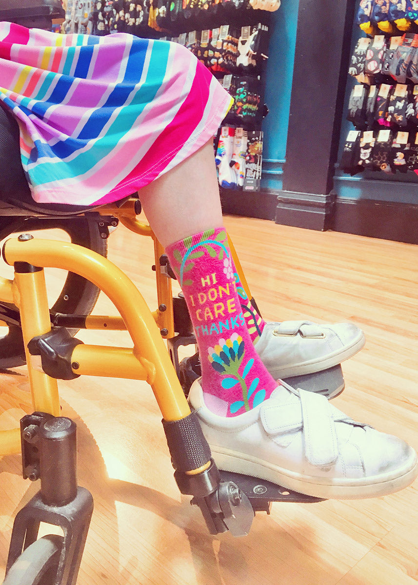 Funny women's socks that say “HI I DON'T CARE THANKS” with a pink floral design.