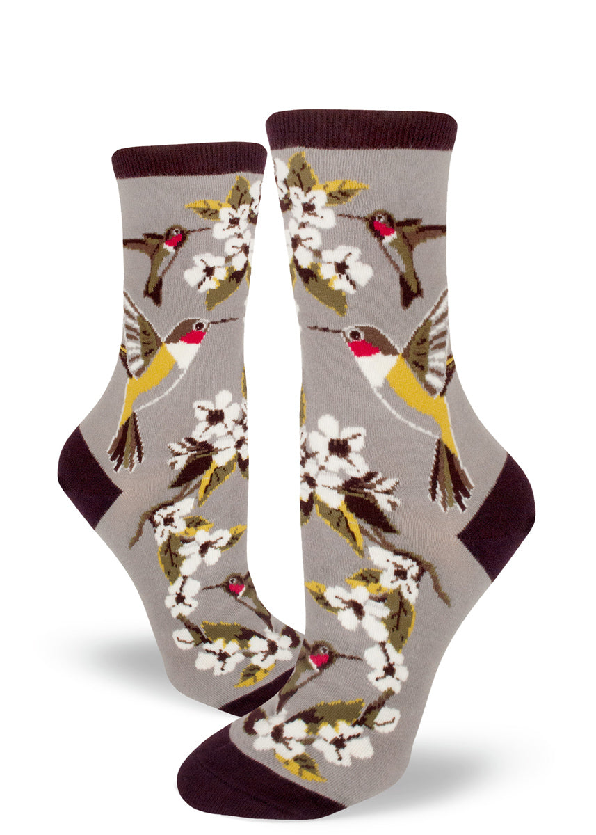 Hummingbird socks for women with ruby-throated hummingbirds drinking nectar from white flowers on a light gray background