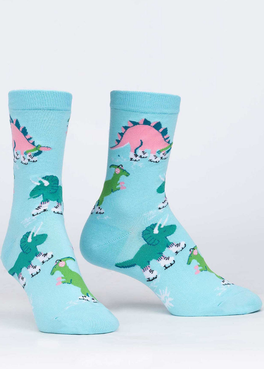 Cute winter socks for women show dinosaurs ice skating while wearing scarves, mittens, and earmuffs!