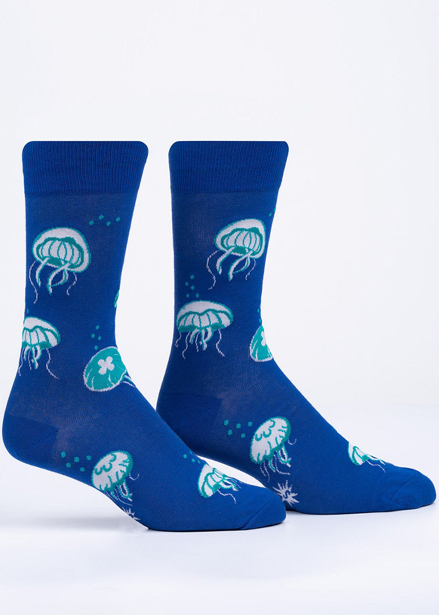 Crew socks for men feature glow-in-the-dark jellyfish on a deep blue background.
