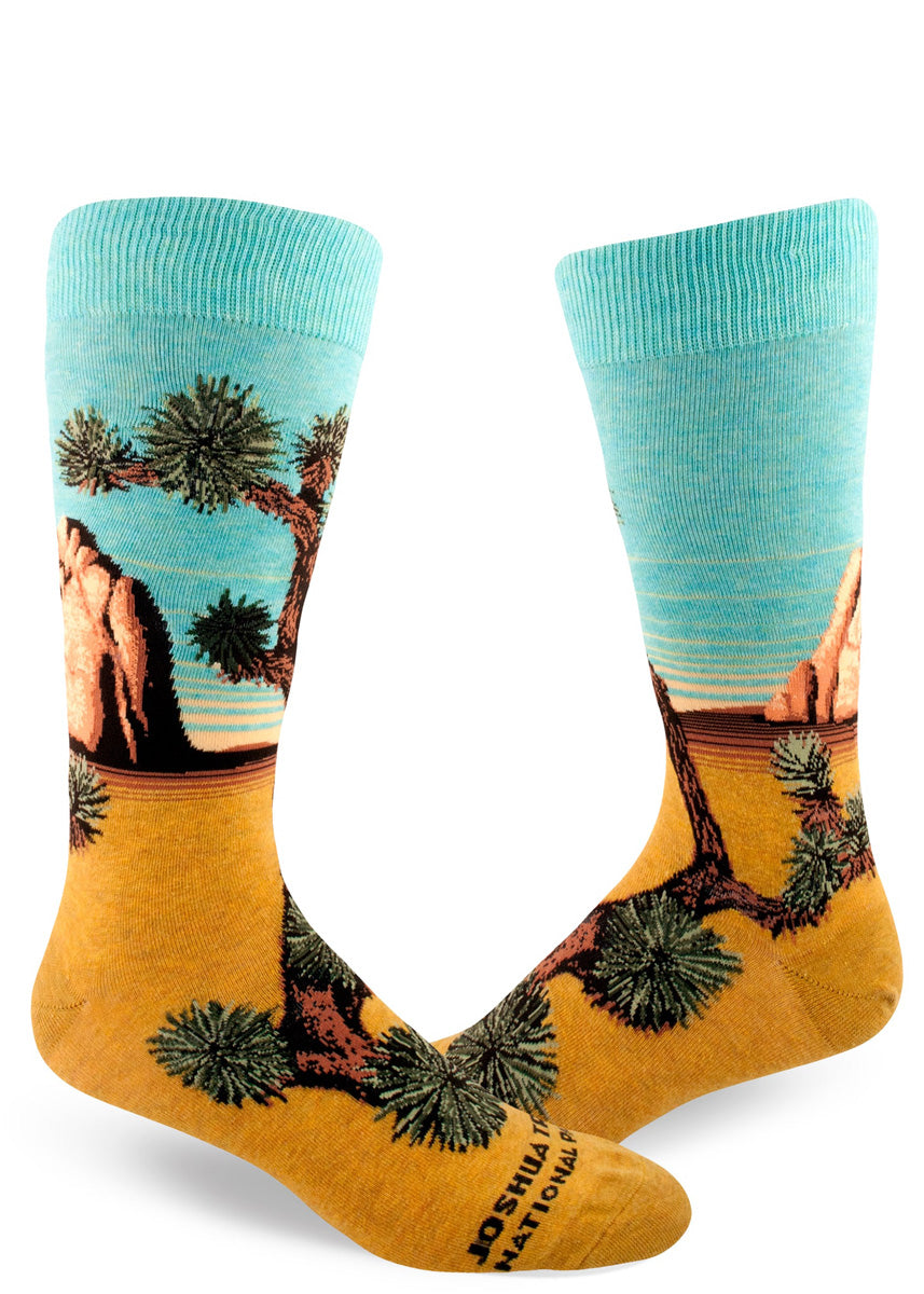 Crew socks for men depict Joshua Tree in all its glory, with golden desert sands, a rock formation, and aqua skies.