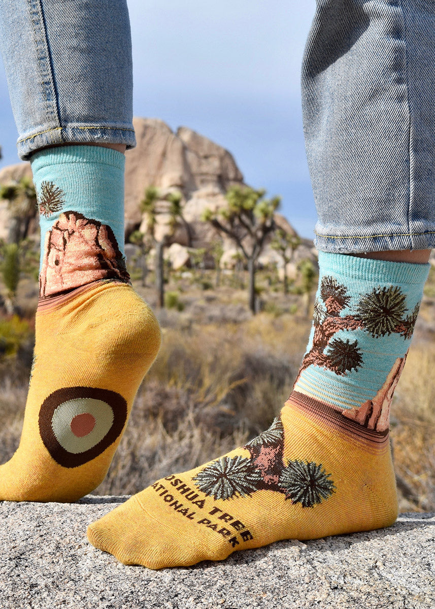 Nature crew socks for women feature a scene from Joshua Tree National Park with yucca trees and boulders.