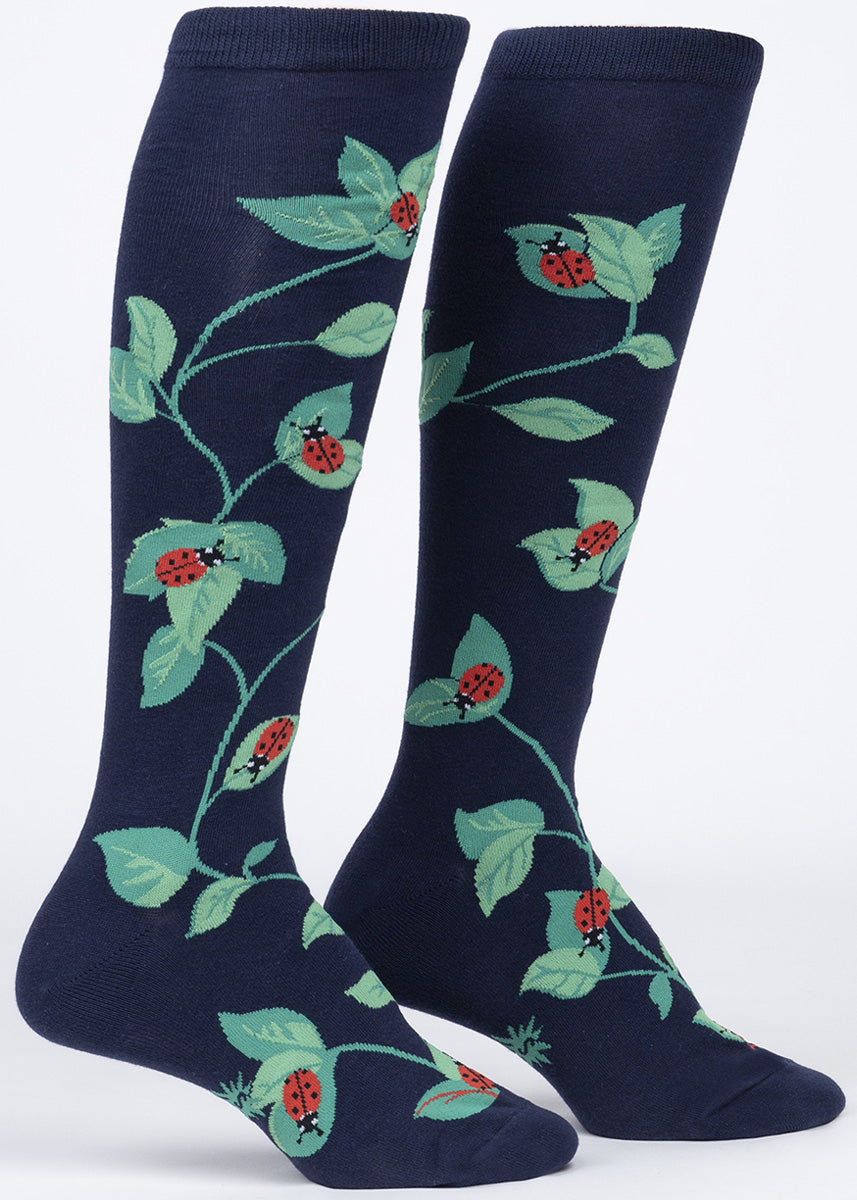 Ladybug knee socks for women feature adorable ladybugs crawling on green leaves.