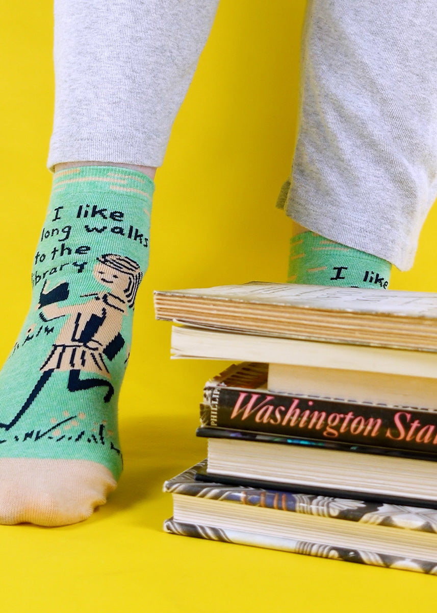 Ankle socks for women show a girl reading with the words, "I like long walks to the library."