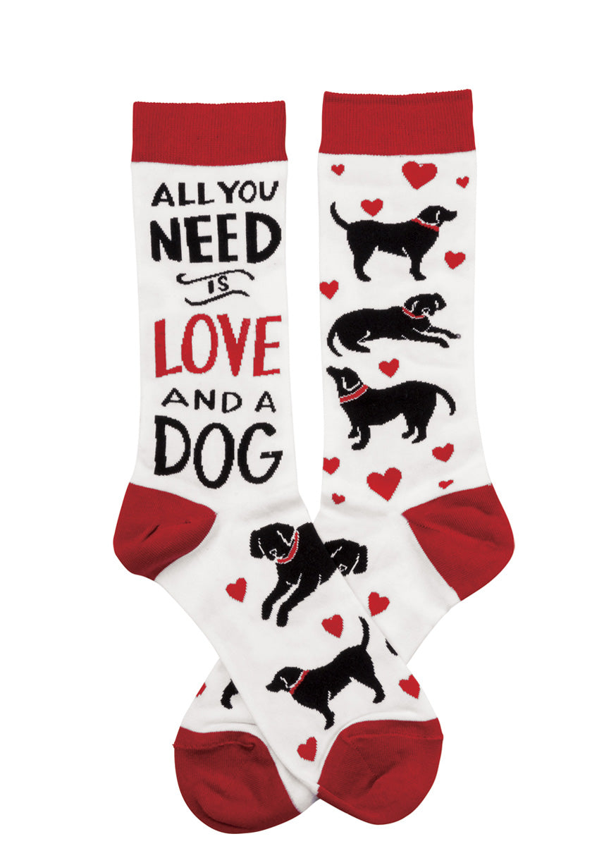 Cute socks for women feature black dogs and red hearts on a white background with the words, "All you need is love and a dog."