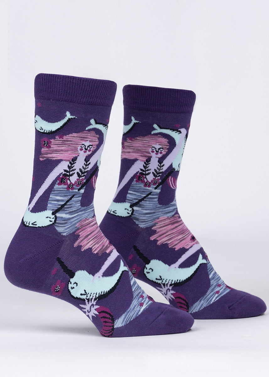 Crew socks for women feature magical mermaids underwater with their narwhal friends on a dark purple background.