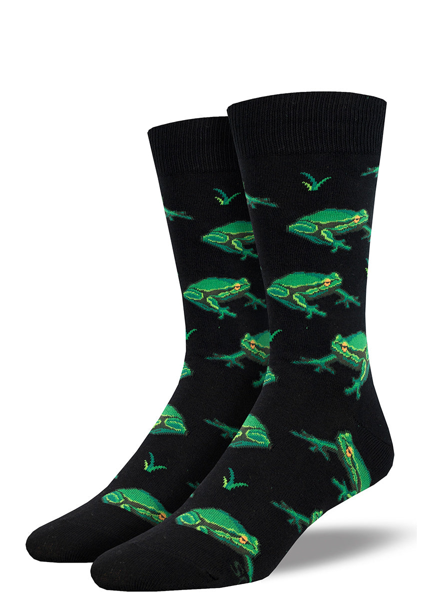Men&#39;s novelty crew socks with a repeating pattern of bright green frogs on a black background. 