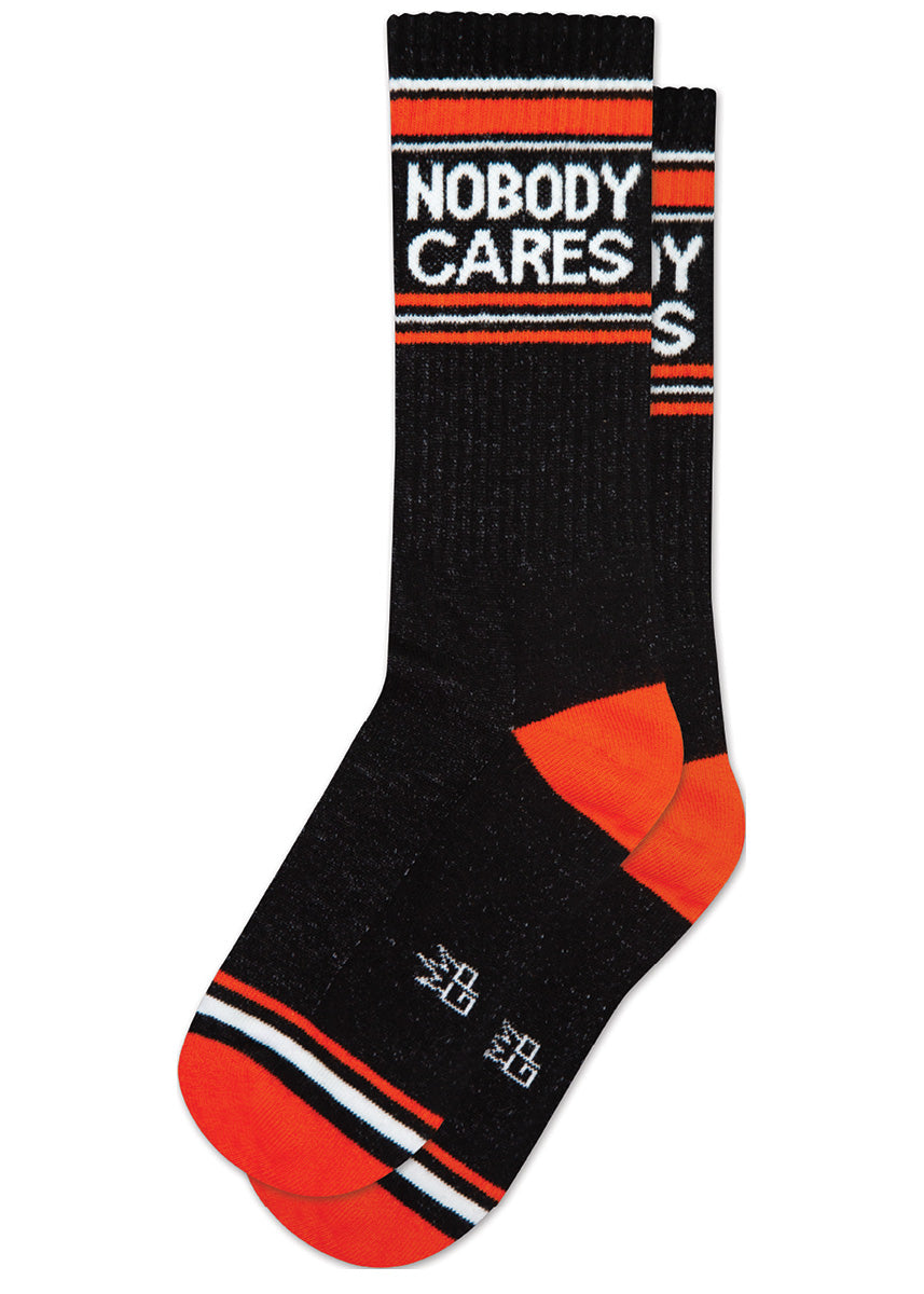 Black retro gym socks with white and orange stripes and the phrase “NOBODY CARES" on the leg.