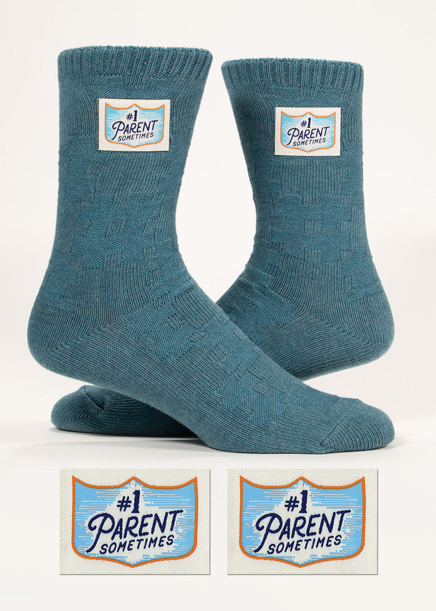 Muted teal cotton crew socks with a textured knit design and sewn-on tags that say &quot;#1 Parent Sometimes.”
