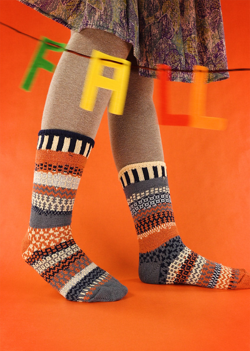 Nutmeg socks from Solmates feature stripes of funky mismatched patterns in orange, pale yellow, gray, and black!
