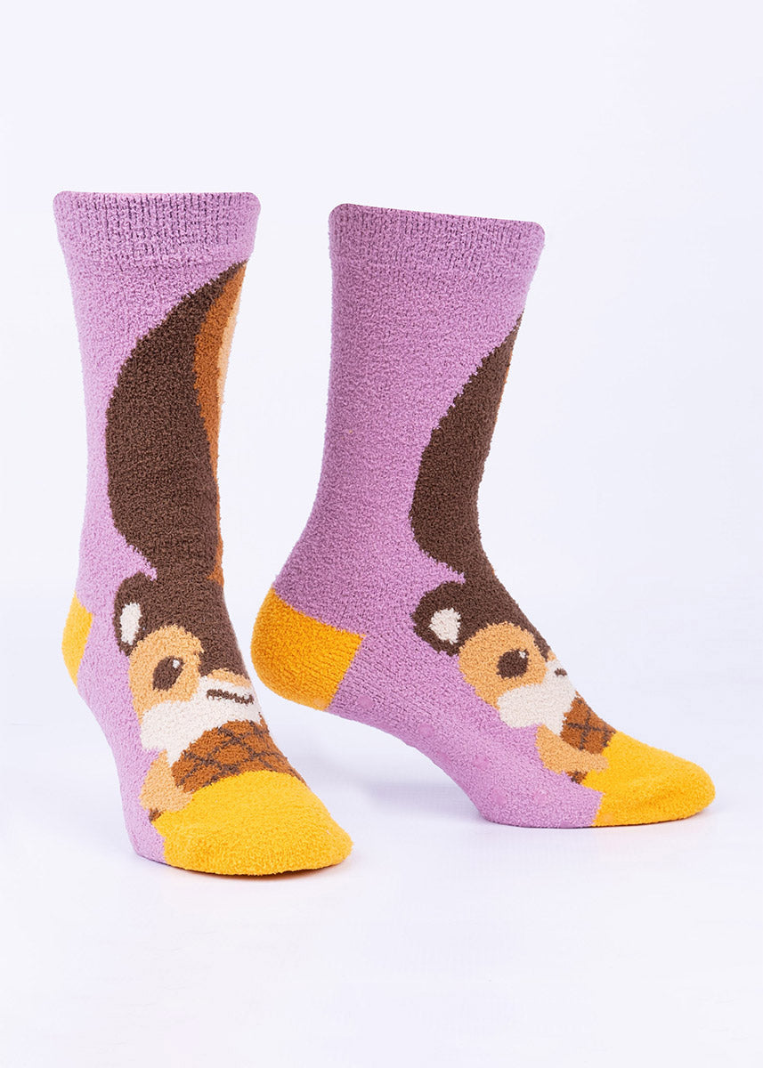 A cute squirrel holds a nut on these crew-high fuzzy slipper socks with a purple background.