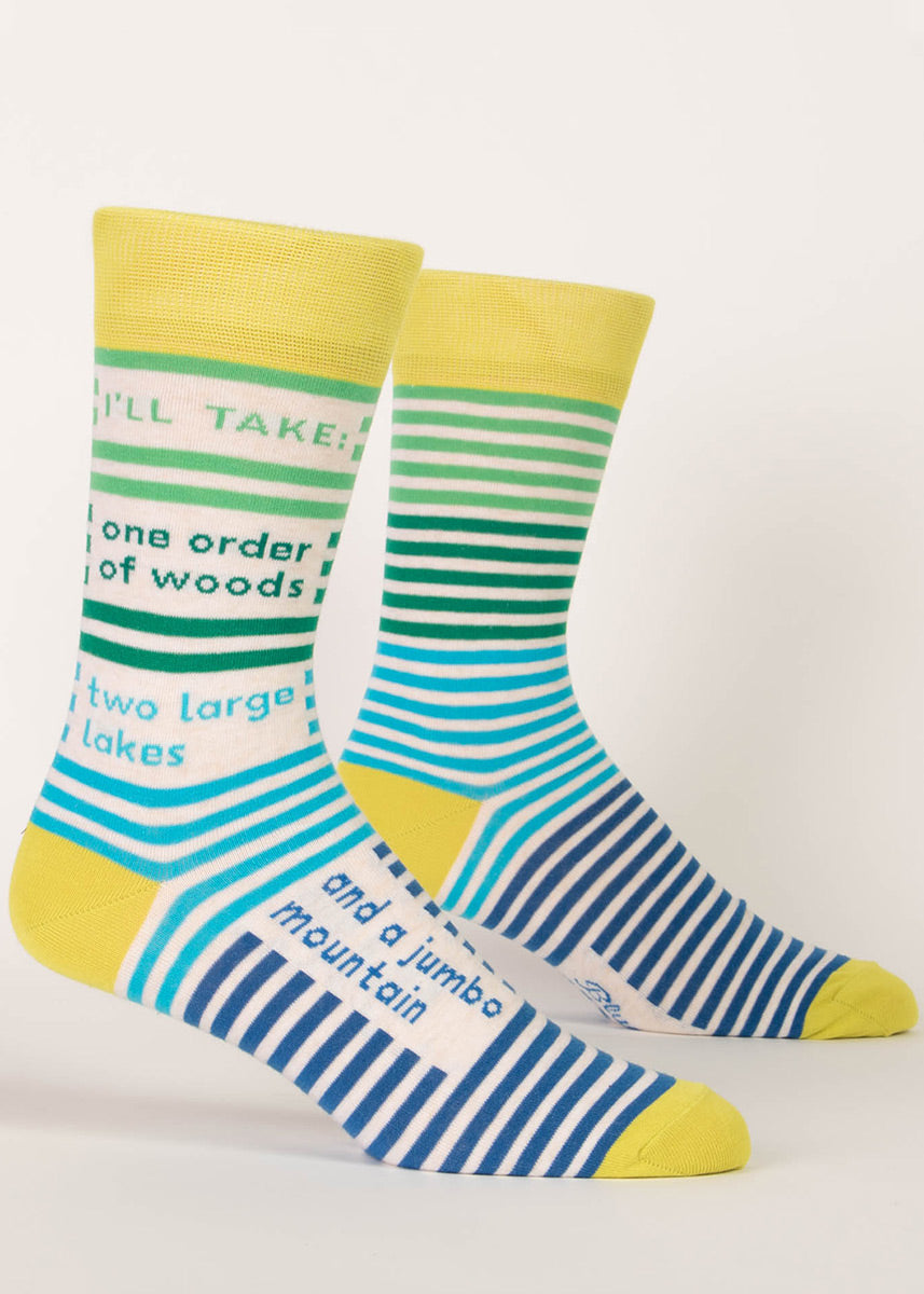Outdoor- themed striped socks for men say “I'll take: one order of woods, two large lakes and a jumbo mountain.” 