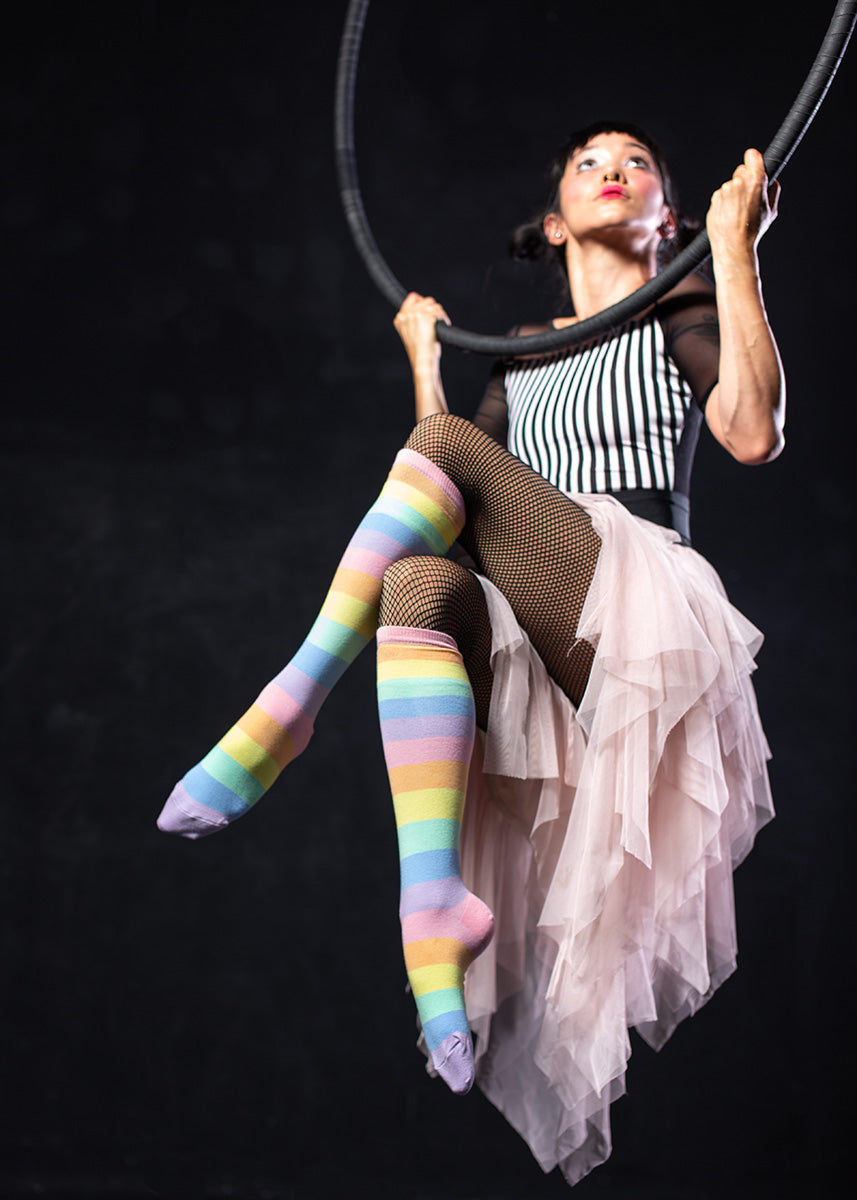 Knee-high socks feature pastel rainbow stripes.