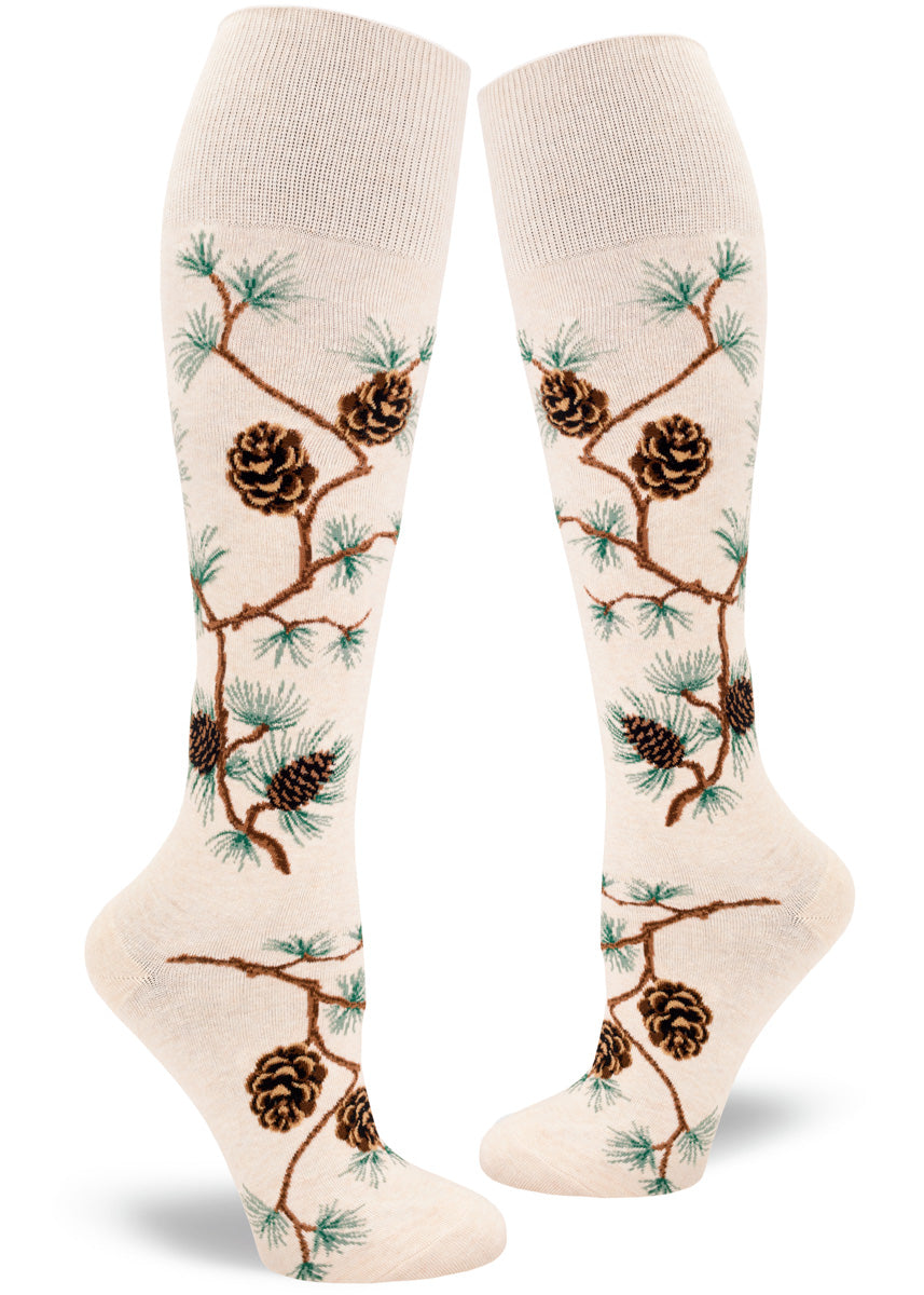 Knee high socks for women feature bending pine branches covered in pinecones and pine needles.