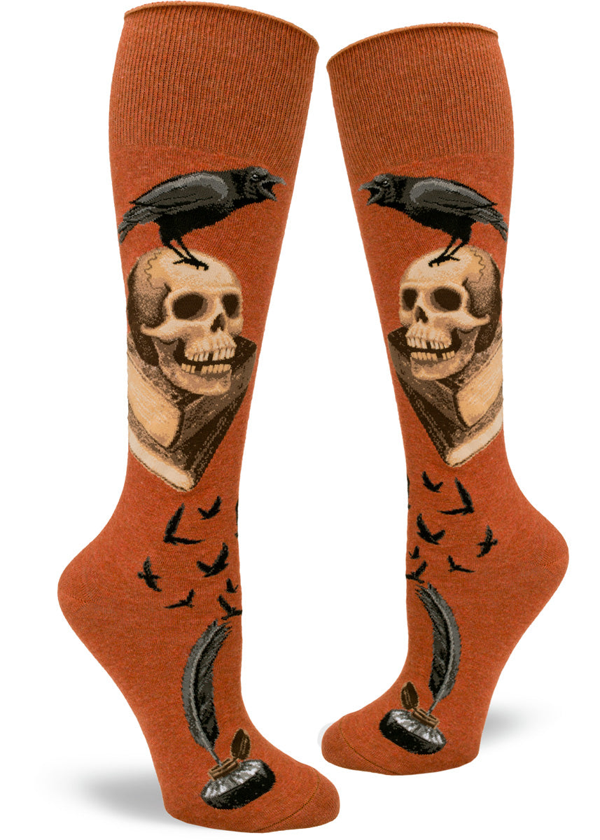 A raven caws from atop a human skull and a pile of books on these spooky knee-highs for women.