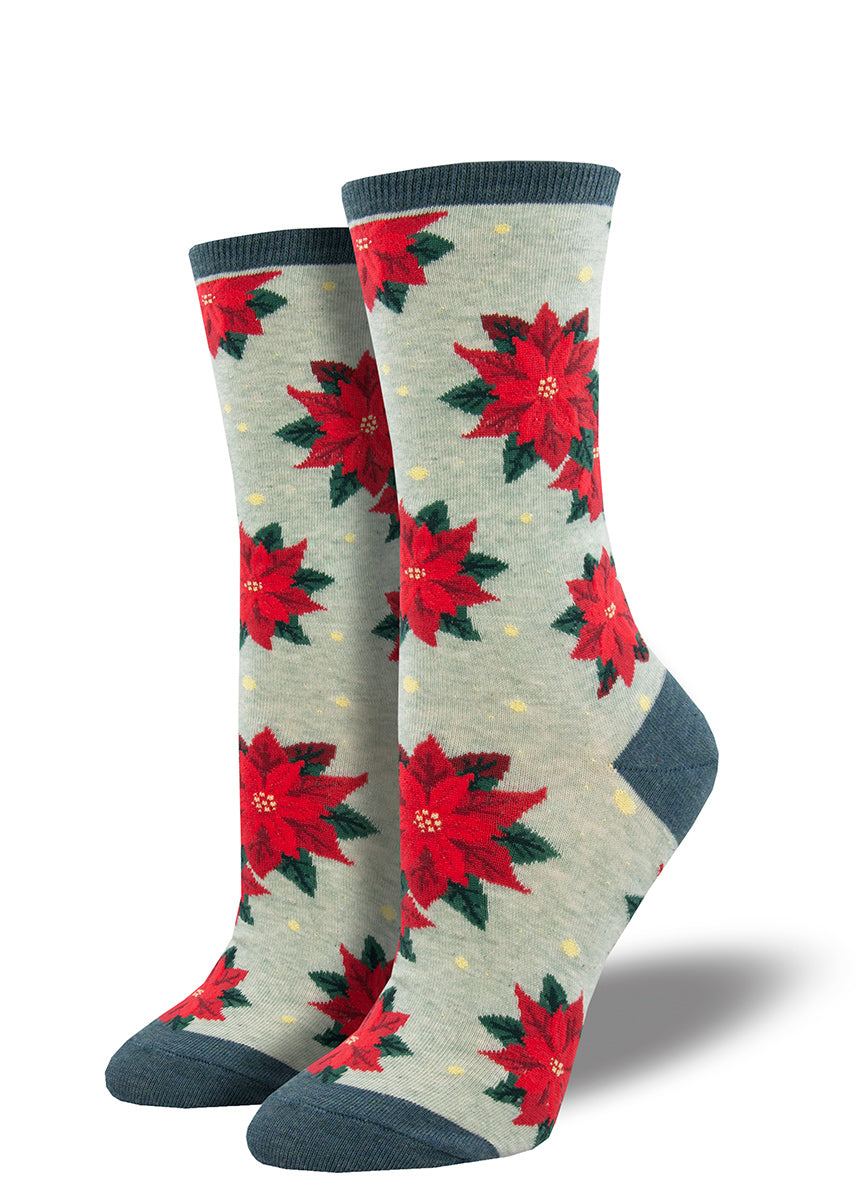 Christmas socks for women feature bright red poinsettia flowers on a heather mint background. 