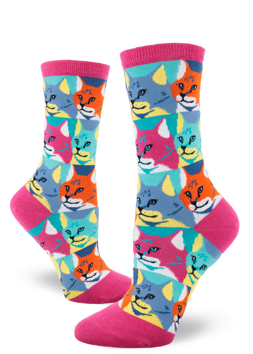 Colorful women&#39;s crew socks with an allover repeating pattern of a cat portrait, each cat face color blocked in bold hues to resemble the silkscreened pop art of the 1960s.