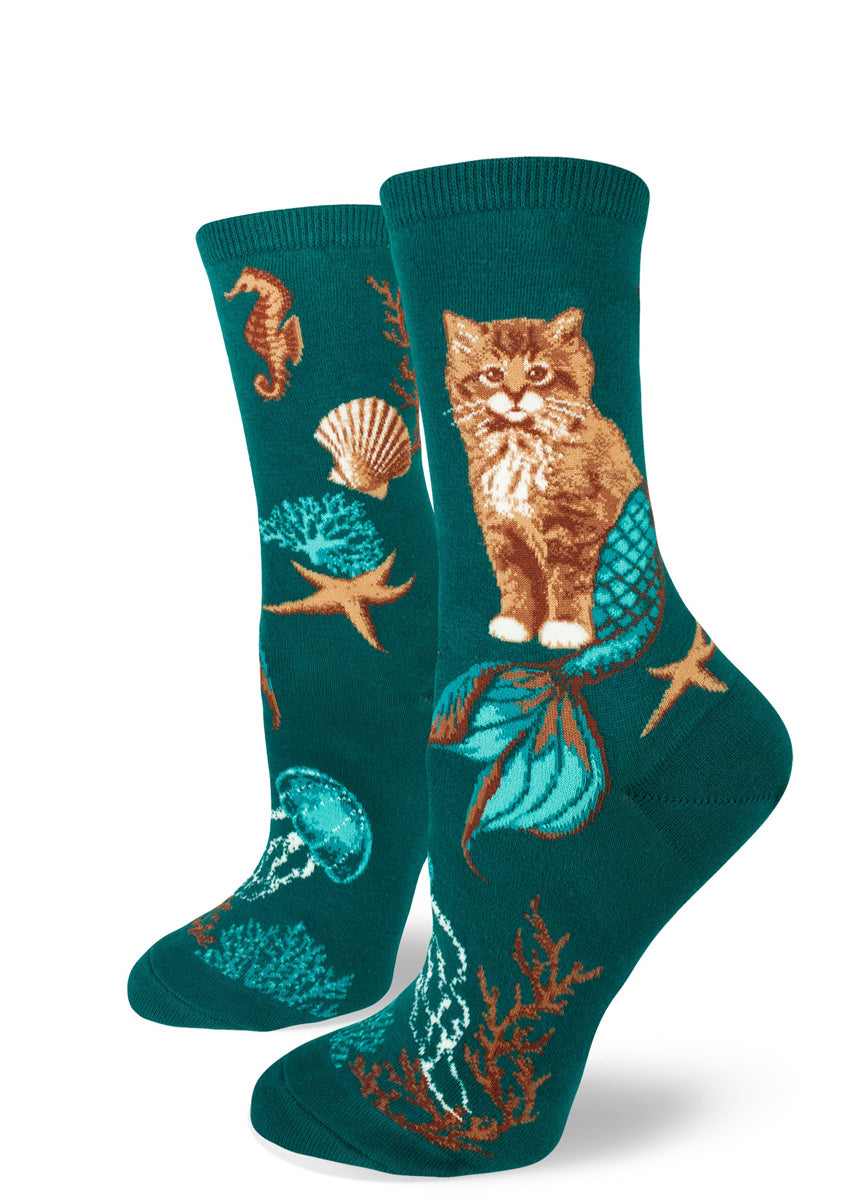 Purrmaid socks for women with cat mermaids and seashells on a teal background