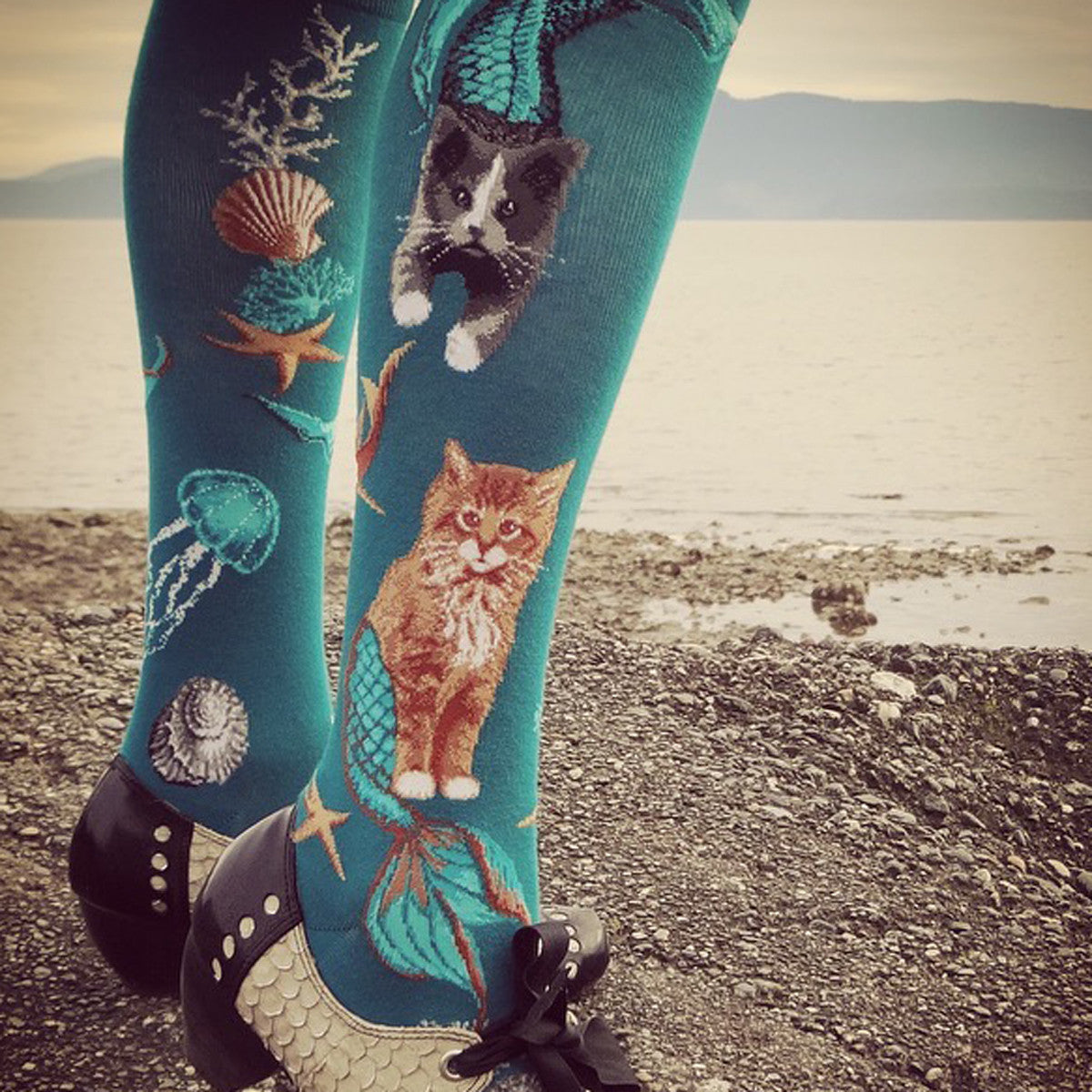 Knee-high purrmaid socks for women with cat mermaids swimming under the ocean on a deep teal background
