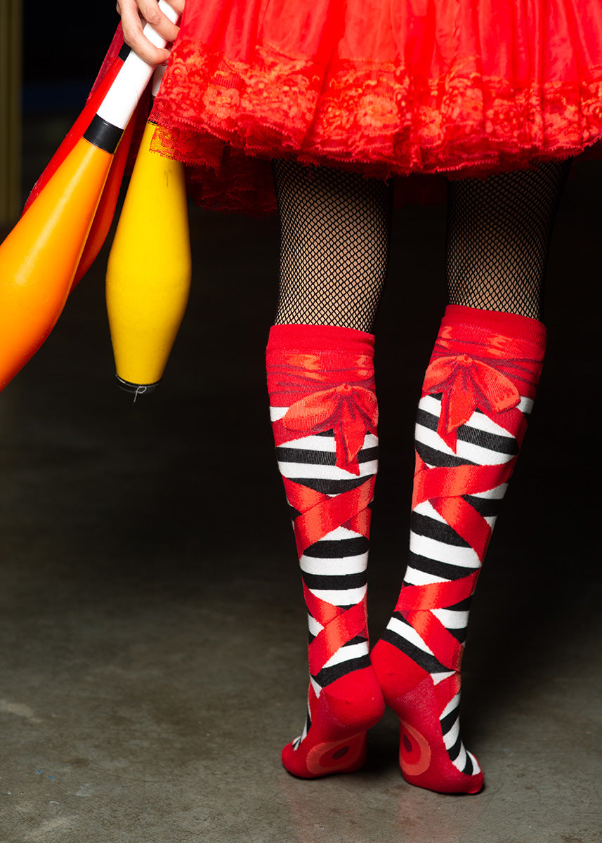 Knee-high ballet socks are made to look like red ballet slippers over black and white striped stockings.