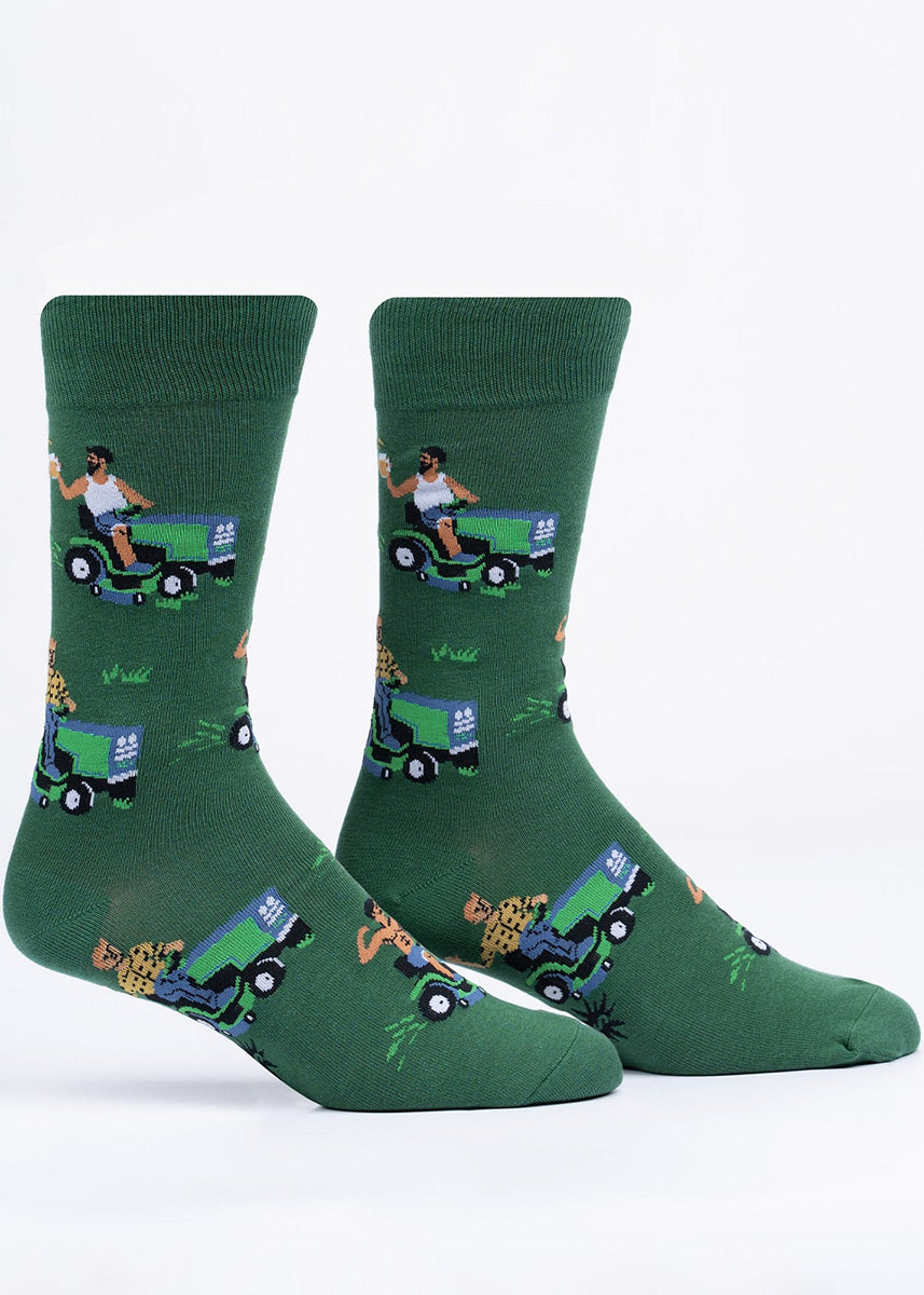 Funny crew socks show men driving riding lawnmowers while they enjoy a cold beer and show off their muscles.