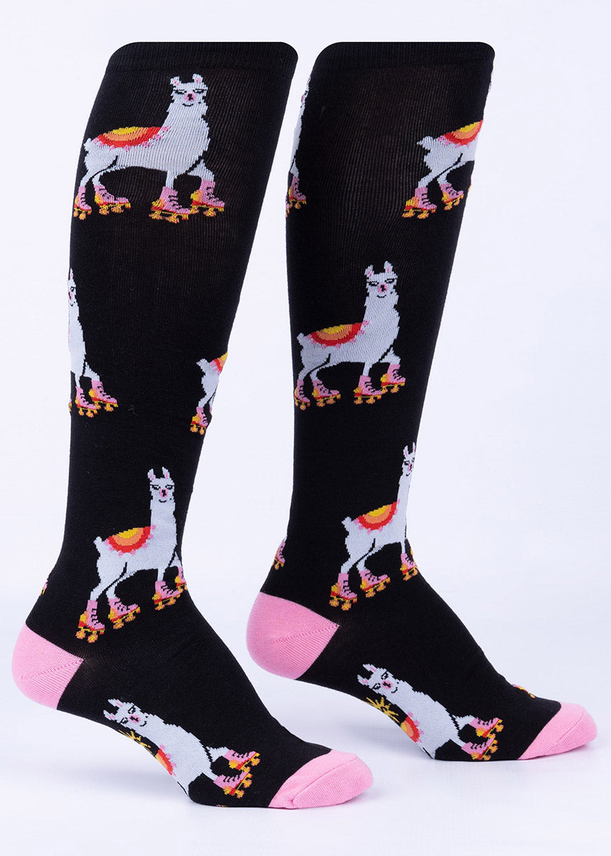 Black knee socks with a repeating pattern of llamas wearing pink roller skates.