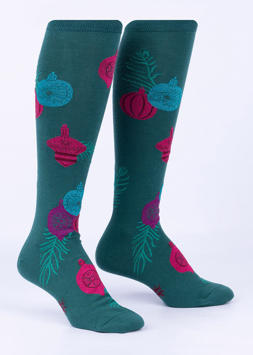 Green Christmas knee socks with shimmering ornaments in pink, purple and blue.