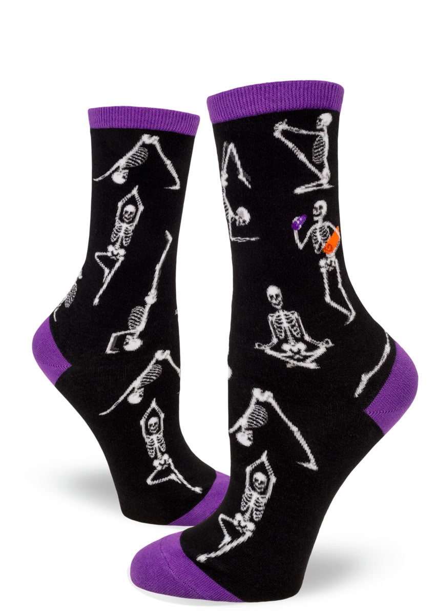 Funny Halloween socks for women show skeletons in different yoga poses and one with a water bottle and yoga mat.