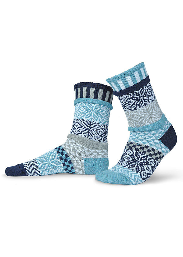 Mismatched crew socks with a subtle knit-in pattern of snowflakes in blues, white and gray.