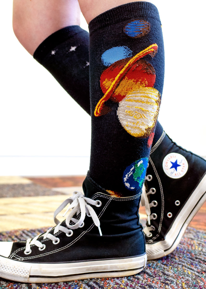Solar system socks for women with the planets, moon & sun going along the knee-high with a black background